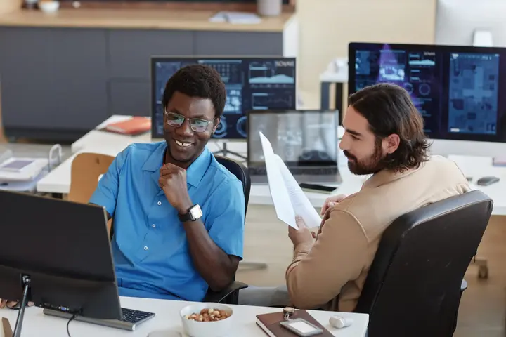 Two IT administrators inspecting a server room.